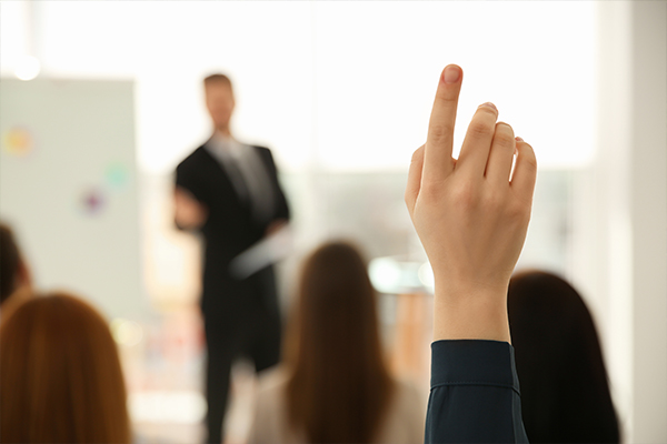 woman raising her hand at a meeting